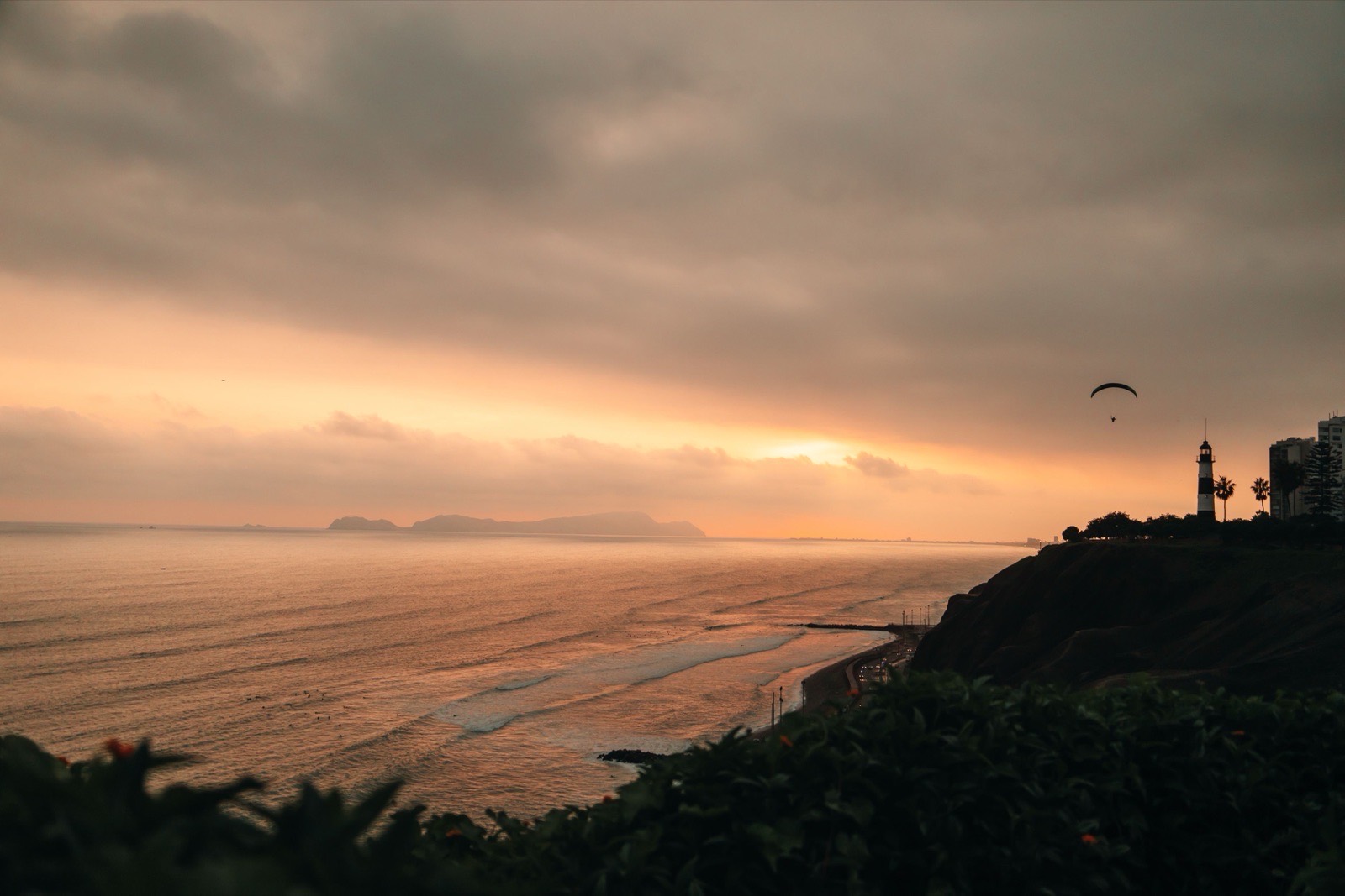 Breathtaking sunset view with a paraglider over the Pacific from Lima, Peru.