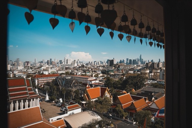 Stunning view of Bangkok city skyline with traditional Thai temples in the foreground.